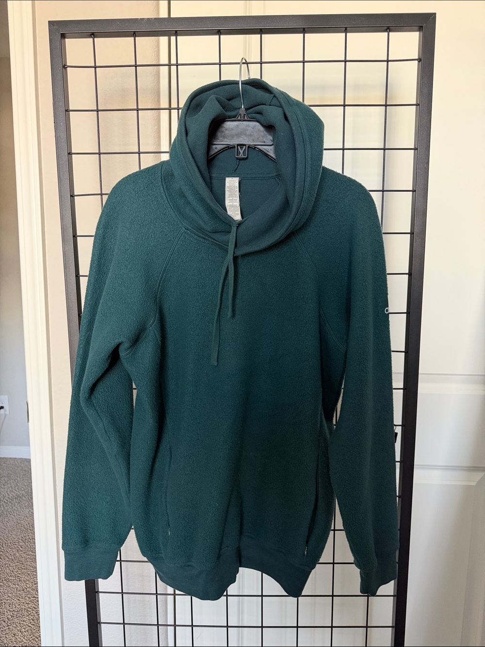 ALO Yoga Woman’s Sherpa Fleece Pullover in Spruce Green with side zip pockets.